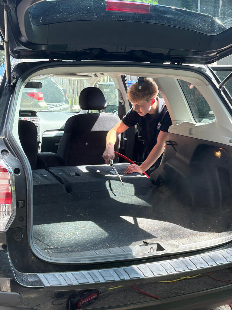 Ben from Four Seasons Detailing cleaning a Subaru Forester in a Minneapolis driveway